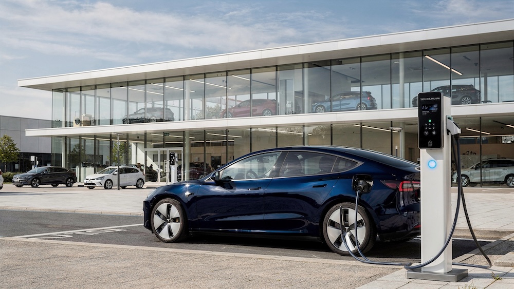 Dunkelblauer Tesla beim Laden vor dem Autohaus