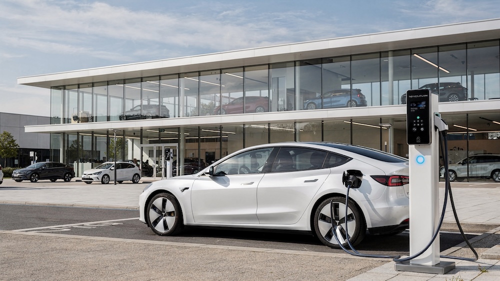 Weißer Tesla beim Laden vor dem Autohaus